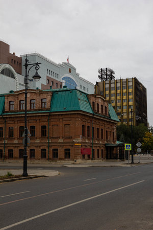 Orenburg, Russia - 03.10.2021: 19th century building in the city center against the background of modern.のeditorial素材