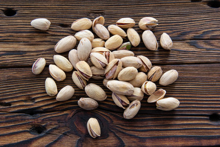 Fried open pistachios on an old wooden table.の写真素材
