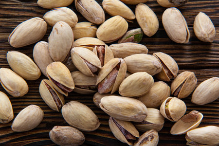 Fried open pistachios on an old wooden table.の写真素材