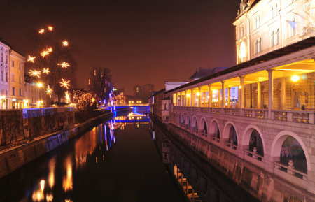 View of Ljubljanica river and its embankment, decorated for Christmas and New Years holidays, Ljubljana, Sloveniaのeditorial素材