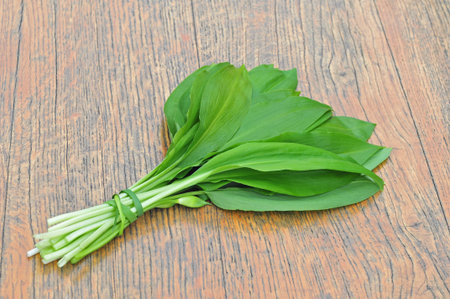 Photo of wild garlic leaves on a wooden table