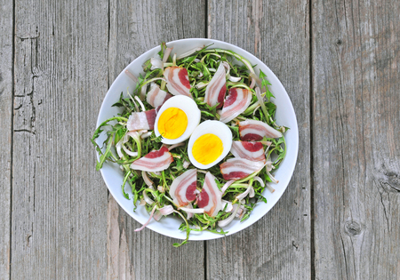 Fresh dandelion salad with boiled eggs and baconの写真素材