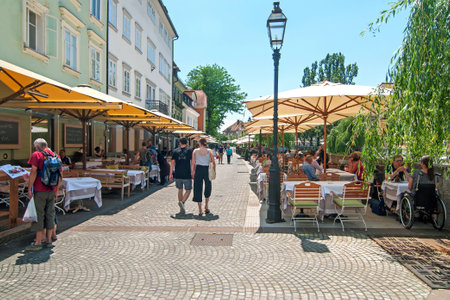 Ljubljana, Slovenia - June 7, 2016 People walking and sitting in cafe bars in Ljubljanas old town center on a bright sunny dayのeditorial素材