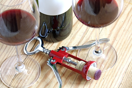 corkscrew with cork , red wine and bottle on wood. top viewの写真素材