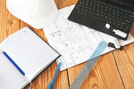 helmet, notebook, drawing tools on wooden plateの写真素材