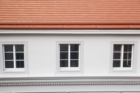 Prague, Czech Republic - July 13 2018: A view to a white house, its three windows and orange roofのeditorial素材