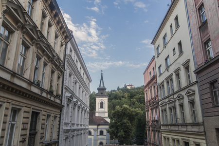 Prague, Czech Republic - July 13 2018: A street surrounded with buildings and the Holy Trinity Church at the endのeditorial素材