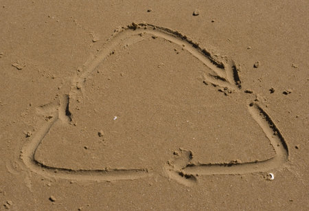 Recycle sign on the sandの写真素材