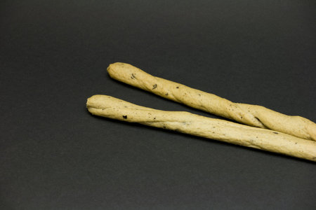 Two bread sticks on black background