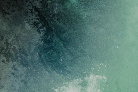 teal blue abstract background with dried watercolor painting on glass surface, abstract ocean waveの写真素材