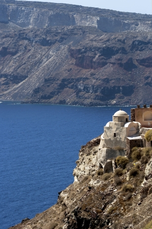 Church on rock verge in the town Oia of Santorini islandの写真素材