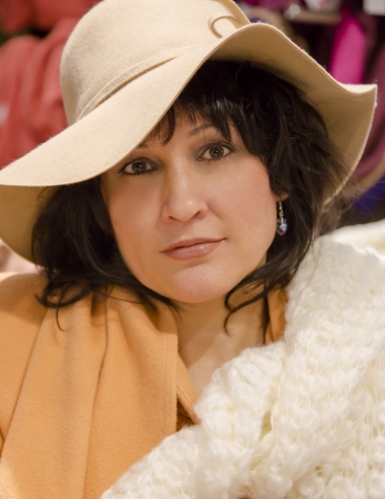 Beautiful elegant lady in a hat and with the white knitted scarfの写真素材