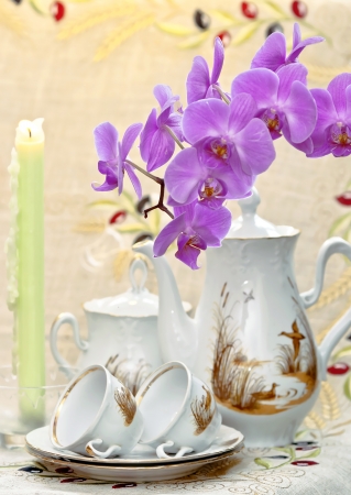 Coffee service for breakfast with flower of living orchid and conflagrant candlesの写真素材