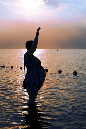 Silhouette of a Pregnant woman at the beach during sunset on Baltic seaの写真素材