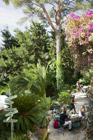 25 08 2013 NICE, FRANCE  Tourists breakfast on an open verandah in a beautiful garden with the pointers of directions to territory of Villa Saint Exupery in Nice, Franceのeditorial素材