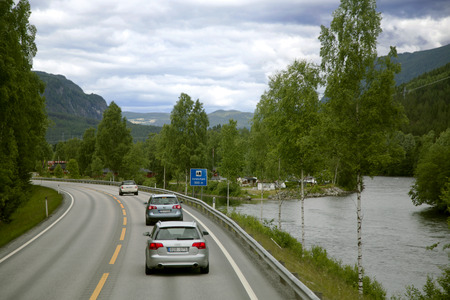 Auto going on a road to fjord winding between mountains in Norway.のeditorial素材