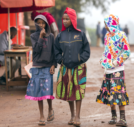 AFRICA, TANZANIA, MAY, 09, 2016 - Three african poorly dressed young girls on the streets in Arusha. Arusha is located below Mount Meru in the eastern branch of the Great Rift Valley and the capital of the Arusha Region.のeditorial素材