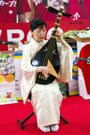 JAPAN, KYOTO, APRIL, 06, 2017 - Woman in Kimono dress is playing the biwa is a Japanese short-necked fretted lute, often used in narrative storytelling in a public place in Kyoto, Japan.のeditorial素材