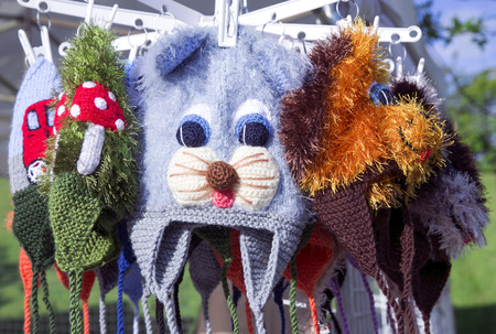 Funny multi-colored crocheted baby hats with appliques on the city marketの写真素材