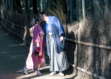 JAPAN, KYOTO, APRIL, 06, 2017 - A loving couple in Japanese national costumes in bamboo forest in Arashiyama, Kyoto, JapanArashiyama is a favorite place for photographing of wedding ceremonies in the western outskirts of Kyoto.のeditorial素材
