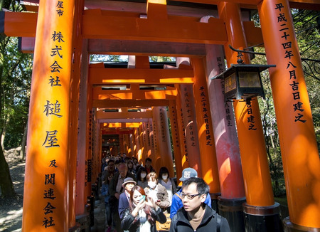 JAPAN, KYOTO, APRIL, 06, 2017 - A large stream of tourists in the temple of Fushimi Inari Taisha at Kyoto, Japan. The shrine is located on which is 233 meters above sea level and includes trails up the mountain to many shrines.のeditorial素材