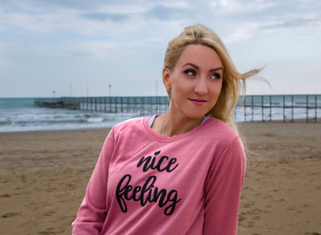 Pretty young blonde near the Mediterranean sea on a cloudy day in Rimini, Italyの写真素材
