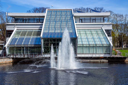 LATVIA, RIGA, APRYL, 2018 - The building is Freeport of Riga Authority and the fountain in front of him on city canal of Riga at Kronvalda Park Bastejkalns, Latvia.のeditorial素材