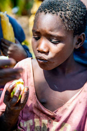 AFRICA, TANZANIA, MAY, 10, 2016 - Portrait african girl of the Hadzabe tribe, that eats fruit in Tanzania, Africaのeditorial素材