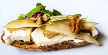 Sandwich with soft blue cheese and slices of sweet pear with herbs and walnutsの写真素材