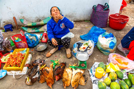 ASIA, VIETNAM, PHAN THIET, NOVEMBER, 15, 2014 - Vietnamese woman eats at the fruit market on Phan Thiet city, Vietnamのeditorial素材