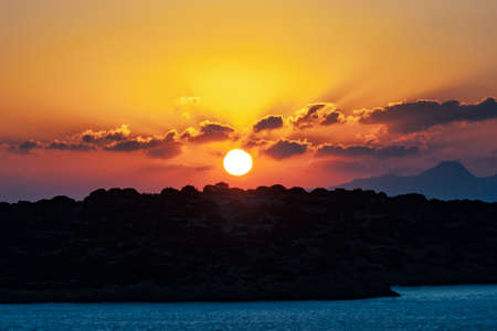 Sunrise in orange tones over the Aegean Sea in Greeceの写真素材