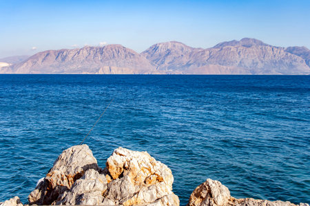 The rocky wild coast of the Aegean Sea is a convenient place for fishing in Crete
