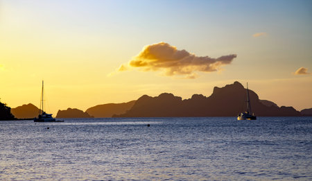 Sunset in yellow tones over Las Cabanas Beach in El Nido, Palawan