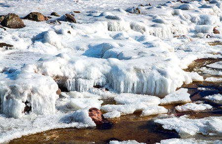 Ice covered rocky coast of the Baltic Sea on wintertime in Latvia.White snow, ice covers the land on...