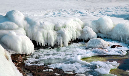 Ice covered rocky coast of the Baltic Sea on wintertime in Latvia. White snow, ice covers the land on seaside.の写真素材