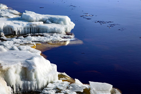 Unusually calm Baltic Sea with ice on the shore on a winter sunny day in Riga, Latvia