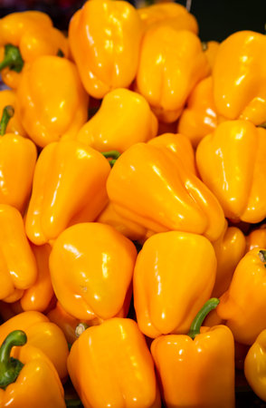 Golden yellow bell peppers laid in grocery shop, yellow bell pepper texture.