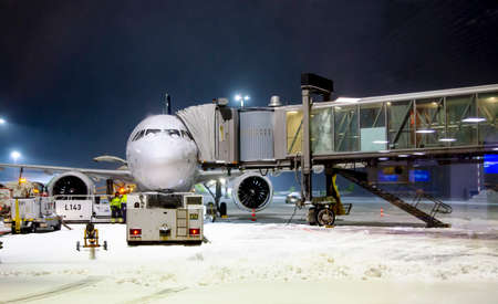 LATVIA, RIGA, MARCH, 2021 - Airplane preparation to fly early winter morning and loading the airplane with baggage in Riga International airport. Latviaのeditorial素材