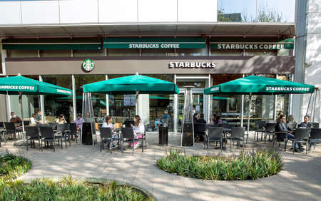 SPAIN, BARCELONA, MARCH, 2021: People drink coffee and communicate live on the open veranda of the Starbucks cafe in Barcelona. Spainのeditorial素材