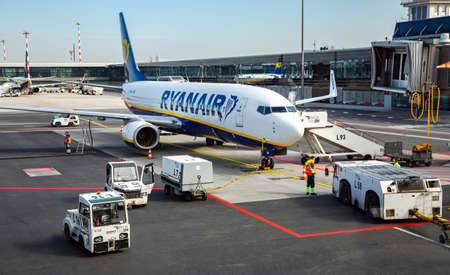 LATVIA, RIGA, MARCH, 2021 - Airplane preparation to fly early morning and loading the airplane with baggage in Riga International airport, Latvia. Airplane ready to taking off on airport.のeditorial素材
