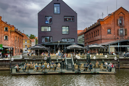 Lithuania, Klaipeda, July, 2020 - People have lunch on the open verandas of the cafe and restaurants...