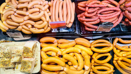 Traditional smoked sausages and lard with spices on the counter in the shopping mall in Riga, Latvia.の写真素材