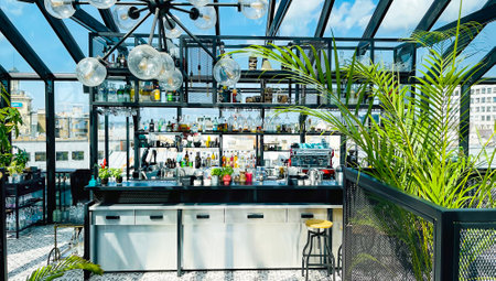 LATVIA, RIGA, AUGUST, 2021 - Cozy modern cafe interior with bar counter under a glass roof in Riga, Latviaのeditorial素材