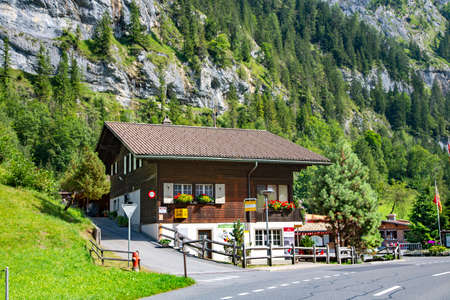 SWITZERLAND, INTERLAKEN, AUGUST 2021 - Ancient wooden house in the mountains overgrown with forest of Bernese Oberland, Switzerland. Typical wooden architecture of Switzerland.のeditorial素材