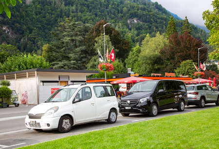 SWITZERLAND, INTERLAKEN, AUGUST 2021 - Hoheweg the main street with parked cars in Interlaken, Bernese Oberland, Switzerlandのeditorial素材