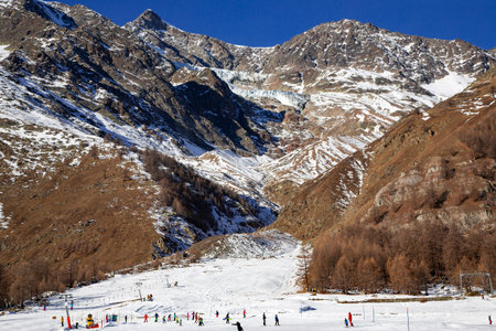 SWITZERLAND, SAAS-FEE, DECEMBER, 26, 2015 - Skiers on snowy slope Felskinn snow sports routes with...