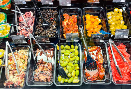 Latvia, Riga, October, 2021 - Various seafood delicacies and olives, sun-dried tomatoes and apricots of high quality in the shopping mall in Riga, Latvia.のeditorial素材