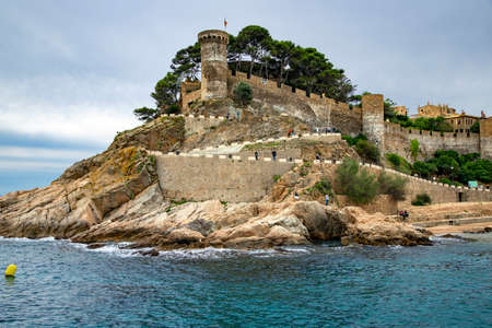 Spain, Catalonia, Lloret de Mar, September, 2021 - Fortress of Tossa de Mar or Vila Vella is visible from the Gran beach. Tossa de Mar is a complex of medieval buildings enclosed by a defensive wall wのeditorial素材