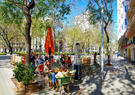 Spain, Barcelona, March, 2021: People dine on the open verandas of cafes and restaurants on the...