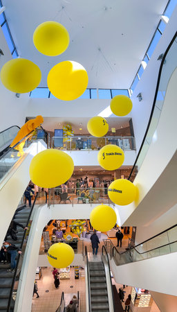 LATVIA, RIGA, MARCH, 2022 - Modern interior of Stockmann shopping mall with big yellow balloons between escalators in Riga, capital of Latviaのeditorial素材